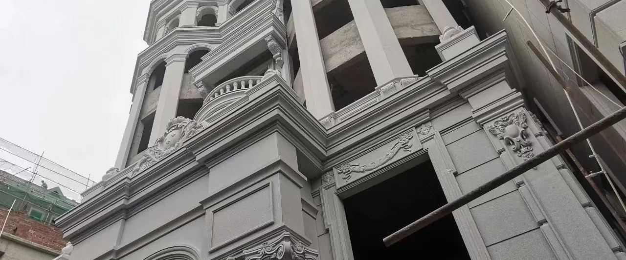 Stone-clad classical building facade with carved architectural detailing